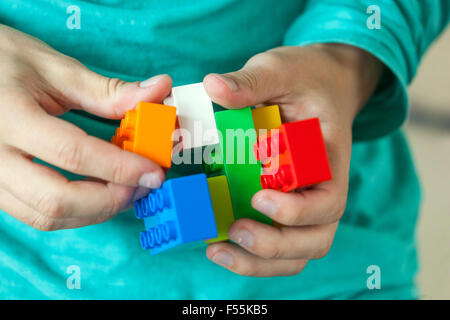 Les cubes en plastique dans les mains d'un jeu d'enfant qui développe la créativité et l'imagination Banque D'Images