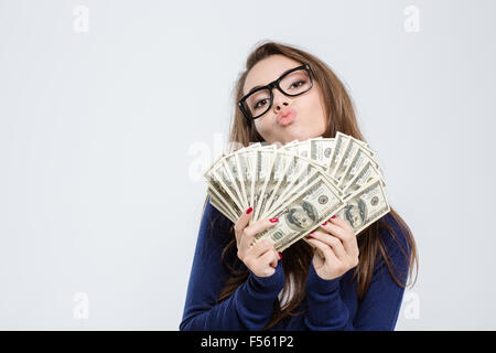 Portrait of a young woman holding projets du dollar et de l'embrasser sur caméra isolé sur fond blanc Banque D'Images