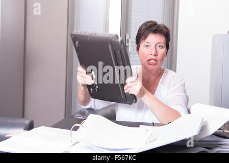 La femme est en train de détruire son PC - surchargé Banque D'Images