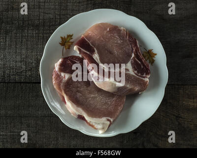 25 octobre 2015 - Matières premières T-bone steak sur whikte sur plaque de table en bois © Igor Goiovniov/ZUMA/Alamy Fil Live News Banque D'Images