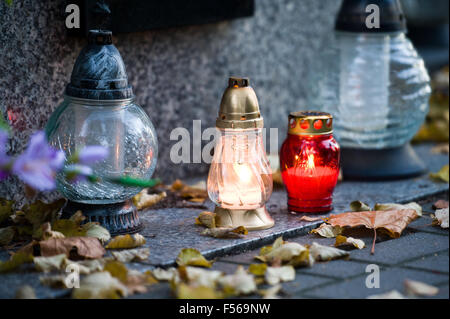 Wielun, Pologne. 28 octobre, 2015. Des bougies allumées sur la tombe, comme une partie des préparations pour célébrer la Toussaint catholique au 1er novembre. Banque D'Images