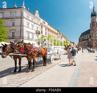 Cracovie, Pologne - 16 mai, 2013. Les touristes se rendant sur place principale du marché, en face de la Basilique Sainte-Marie, à Cracovie, Pologne, Europe. Banque D'Images