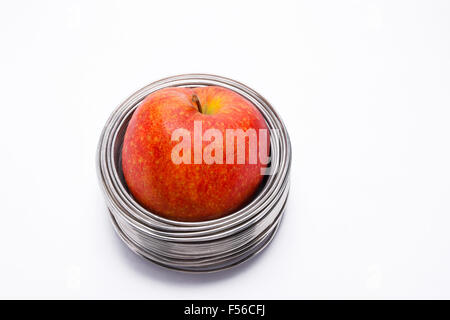 Apple filaire : ensemble pomme rouge dans des bobines de fil aluminium isolé sur fond blanc Banque D'Images