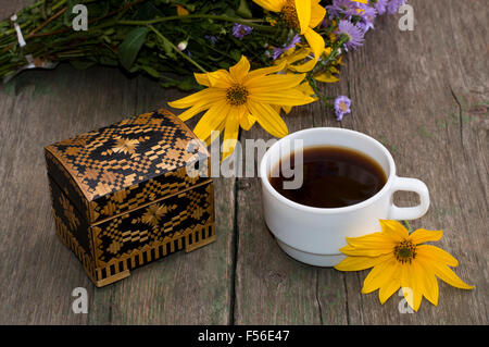 Tasse de café, de fleurs sauvages, et fleur jaune, still life, sur une table en bois Banque D'Images