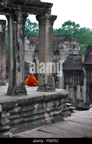Deux jeunes moines bouddhistes photographiés de derrière donnent sur le complexe d'Angkor Wat, au Cambodge. Banque D'Images