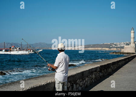 Un pêcheur tente sa chance patiemment le long du front de mer de La Canée en Crète en Grèce Banque D'Images