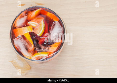 Sangria vin au verre à vin et des morceaux de glace sur une table en bois Banque D'Images