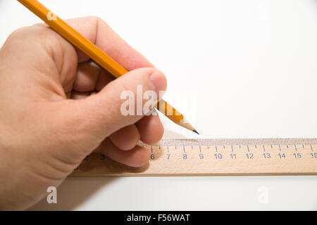 Men's main gauche tenant un crayon sur un livre blanc Banque D'Images