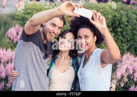 Deux femmes et un homme selfies posant pour une Banque D'Images