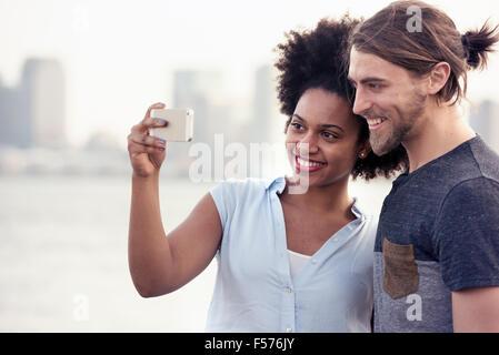 Un couple, homme et femme, en tenant une par le front de selfies dans une ville Banque D'Images