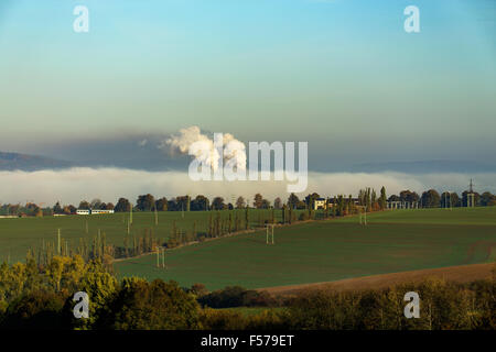 Ecologic non fumeurs dans les cheminées de l'usine cachée dans morning mist over rural landscape Banque D'Images
