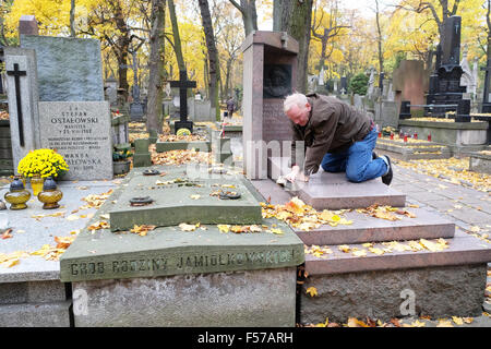 Cimetière Powazki, Varsovie, Pologne - Jeudi 29 octobre 2015 - Un homme nettoie un caveau familial de feuilles tombées en préparation de la toussaint pour la célébration le dimanche 1er novembre. Est le plus grand cimetière Powazki à Varsovie. Banque D'Images