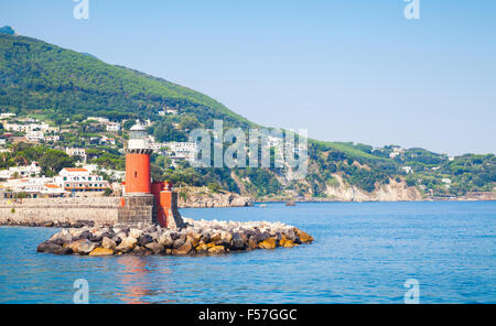 La tour phare rouge sur les brise-lames en pierre. Entrée à Ischia Porto. Mer Méditerranée, Italie Banque D'Images