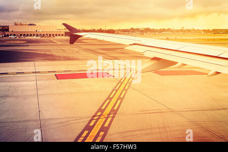 Tons Vintage aile d'avion au-dessus de la piste au coucher du soleil, concept de voyage. Banque D'Images