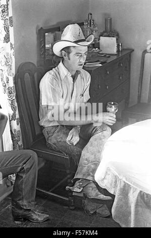 Un cowboy ranch appelé Ray Howe se trouve dans la cuisine d'une maison du ranch au nouveau mexique et boit un verre de thé glacé. Banque D'Images