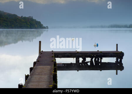 Une jetée se dresse sur le lac Ullswater à Howtown au lever du soleil dans le Parc National du Lake District, Cumbria, England, UK, FR. Banque D'Images