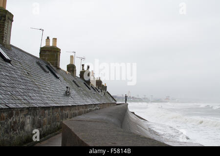 Footdee, Aberdeen, Écosse, Royaume-Uni - 29 octobre 2015 : France - une saison humide et venteux début de journée à Aberdeen en jeune homme photographies le surf à l'extérieur d'une ancienne maison de pêcheur en kayrtravel Footdee : Crédit/Alamy Live News Banque D'Images