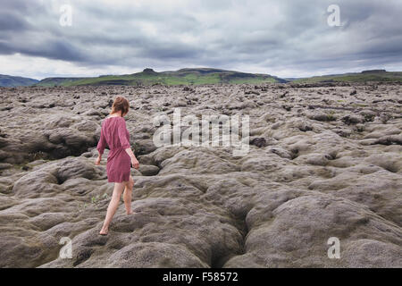 Fashion femme marchant pieds nus dans les champs de lave en Islande Banque D'Images