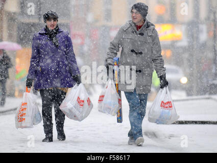 Transporter les acheteurs shopping dans la neige lourde dans Pontypridd, Pays de Galles du Sud. Banque D'Images