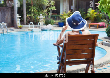 Vacances d'été, woman relaxing in bel hôtel de luxe proche piscine Banque D'Images