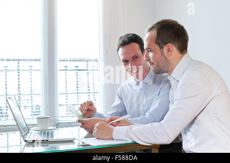 Deux smiling happy business hommes travaillant sur le projet au bureau