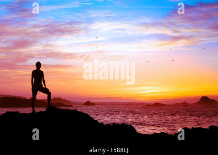 Concept de bien-être, silhouette de personne bénéficiant de beau coucher de soleil avec vue sur l'océan Banque D'Images