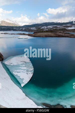 Plaque de glace flottent dans le lac glaciaire 'Totensee' sur le dessus de col du Grimsel, Suisse (altitude 2165m). Banque D'Images