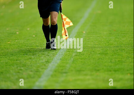 Arbitre assistant le long de la ligne de côté pendant un match de foot Banque D'Images