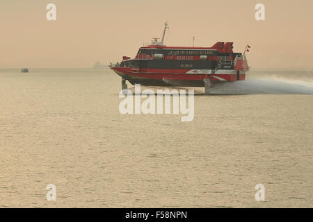 Lever du soleil sur l'or, l'hydroglisseur turboréacteur Cacilhas, passant de l'Île Lamma, Enroute de Macao à Hong Hong. Banque D'Images