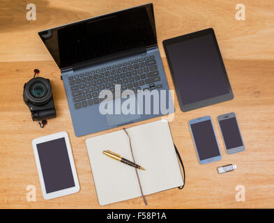 Vue de dessus de bureau avec ordinateur portable, smartphones, tablettes, appareil photo et carnet et un stylo numérique - design / concept évolution Banque D'Images