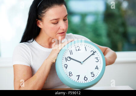 Réglage de la femme à l'heure d'une horloge Banque D'Images