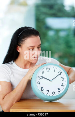 Réglage de la femme à l'heure d'une horloge Banque D'Images