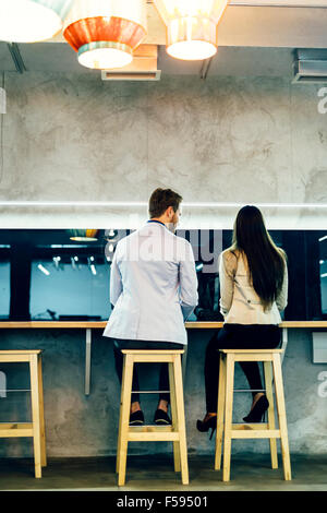 Bel homme de parler à une femme tout en étant assis sur des chaises ar Banque D'Images