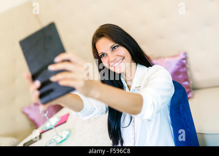 Belle jeune femme prenant une des selfies elle-même dans un restaurant. Banque D'Images