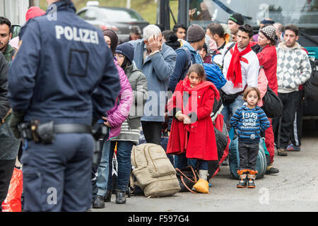 Wegscheid, Allemagne. 30Th Oct, 2015. Les réfugiés se tenir sur la partie autrichienne de l'German-Austrain frontière près de Wegscheid, 30 octobre 2015. au premier plan est un membre de la police autrichienne. Photo : ARMIN WEIGEL/DPA/Alamy Live News Banque D'Images