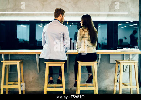 Jeunes collègues conversant pendant les heures de pause dans un restaurant. Banque D'Images