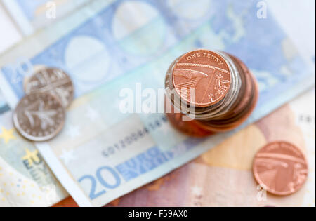 La pièce d'un penny sur une pile et 20 Euro note Banque D'Images