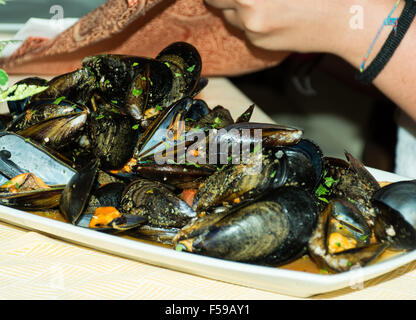 Un plat de moules des photos avec la sauce tomate, ouvert, prêt à manger, d'une table se propager. Banque D'Images