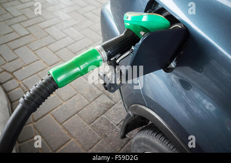 Voiture bleu foncé moderne de remplissage avec de l'essence à une station automatique Banque D'Images