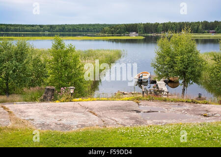 Petit bateau amarré à la jetée dans le lac d'entrée par le long d'une soirée d'été Banque D'Images