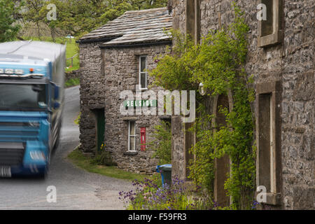 Grande vitesse camion passé, dangereusement près de cottages en pierre traditionnelle route doublure - charmant hameau de Armoy, North Yorkshire, Angleterre, Royaume-Uni. Banque D'Images