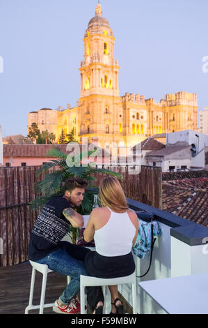 Jeune couple à bar sur le toit offrant une Cathédrale illuminée en arrière-plan. Auberge urbaine Chinitas Pje. Chinitas, 3 Malaga, Andalousie, Banque D'Images