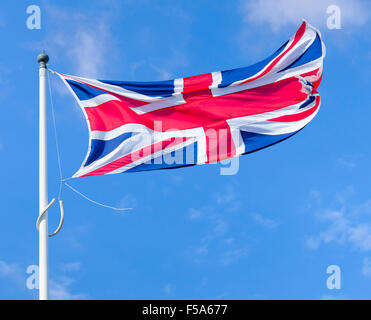 Union Jack, drapeau du Royaume-Uni de Grande-Bretagne et d'Irlande du Nord, battant sur un poteau contre le ciel bleu. Banque D'Images