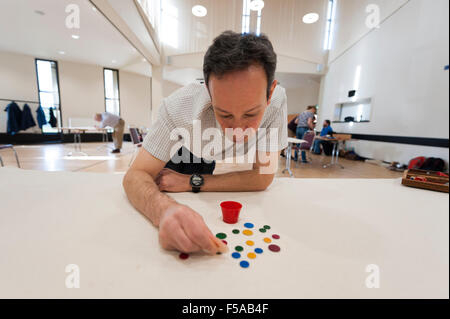 Cambridge, UK. 31 octobre, 2015. Patrick Barrie (Champion National) prend fin. La fortune anglais paires National Championships ont lieu à Selwyn College Cambridge UK. Loin d'être un jeu d'enfant, la concurrence est un mélange de stratégie et de dextérité pour propulser les "winks" à l'aide d'un "squidger" dans un pot, ou pour couvrir les opposants "winks". La naissance du jeu moderne peut être attribuée à un groupe d'étudiants de Cambridge (Royaume-Uni) en 1955. Credit : Julian Eales/ Alamy Live News Banque D'Images