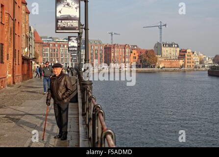 Gdansk, Pologne 31st, octobre 2015 Eldery homme marche sur la rivière Motlawa banque. Peu de touristes a décidé de visiter le centre-ville historique de Gdansk. Le samedi 31 mai. Le temps est ensoleillé mais très froid, la température ne dépasse pas 5 degrés Celsius. Credit : Michal Fludra/Alamy Live News Banque D'Images