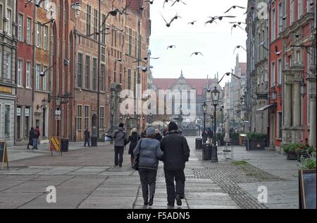 Gdansk, Pologne 31er octobre 2015, les gens regardent les pigeons à la rue Dluga à Gdansk. Peu de touristes a décidé de visiter le centre-ville historique de Gdansk. Le samedi 31 mai. Le temps est ensoleillé mais très froid, la température ne dépasse pas 5 degrés Celsius. Credit : Michal Fludra/Alamy Live News Banque D'Images