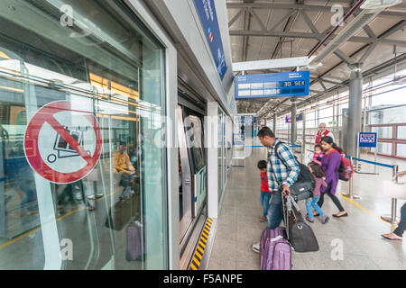 L'aéroport de Francfort, Allemagne. Une famille entre dans le train monorail Skyline, qui voyage entre les bornes. Banque D'Images