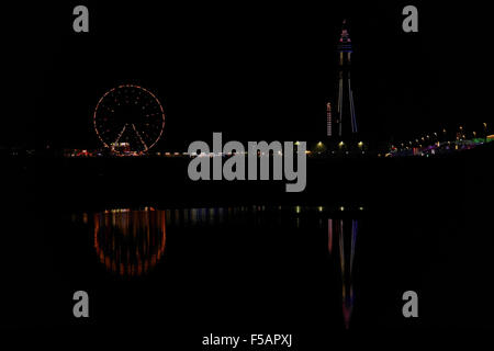 Vue sur la plage de nuit, vers le nord, avec des reflets de couleur verte, la Blackpool Tower et Blackpool Central Pier, Illuminations Banque D'Images