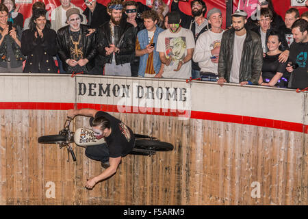 Personnes dans halloween fancy dress regardant un stunt bike rider tour le mur de la mort / drome démon au bal masqué à Cornwall 2015 Banque D'Images