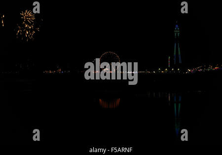 Nuit vue sur la plage, au nord de la tour de Blackpool, feux d'artifice explosent au-dessus de Central Pier avec grande roue, illuminations de Blackpool, Royaume-Uni Banque D'Images